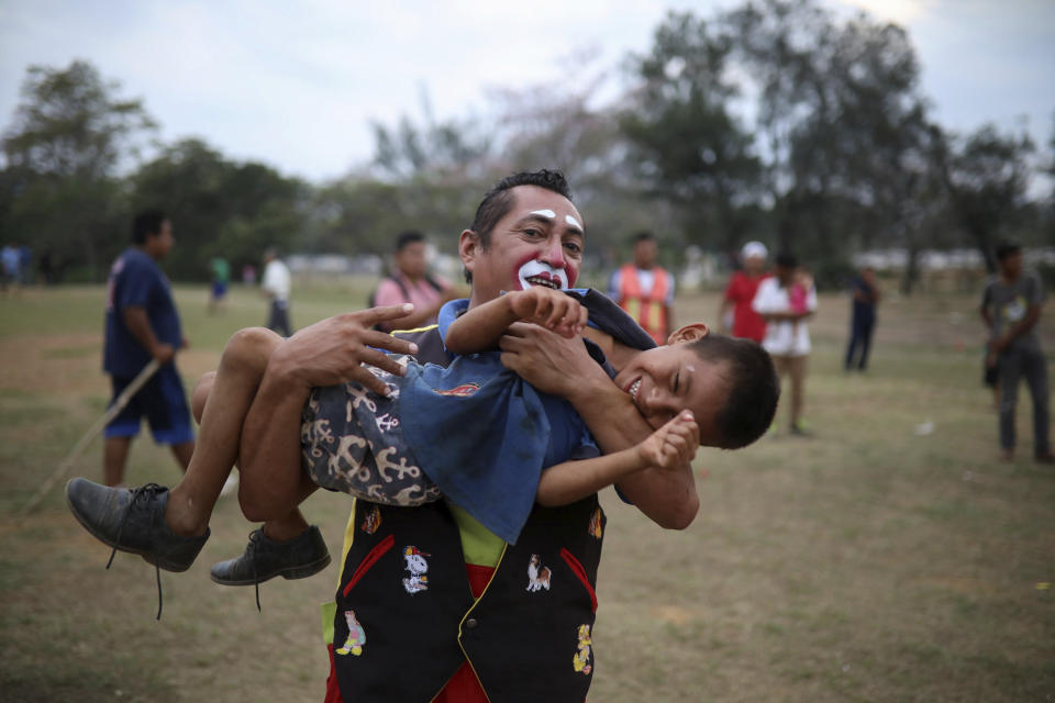 <p>A boy laughs as he plays with a Mexican clown named “Chocolate” at the sports club where Central American migrants traveling with the annual Stations of the Cross caravan have been camped out, at a sports club in Matias Romero, Oaxaca State, Mexico, Wednesday, April 4, 2018. (Photo: Felix Marquez/AP) </p>