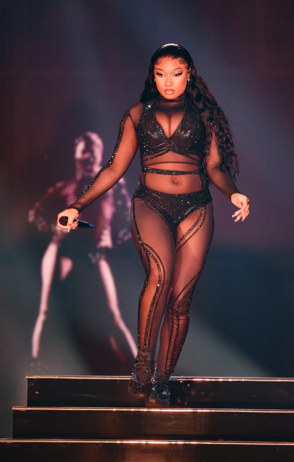 Megan Thee Stallion wears a see-through, black set at the 2020 American Music Awards.