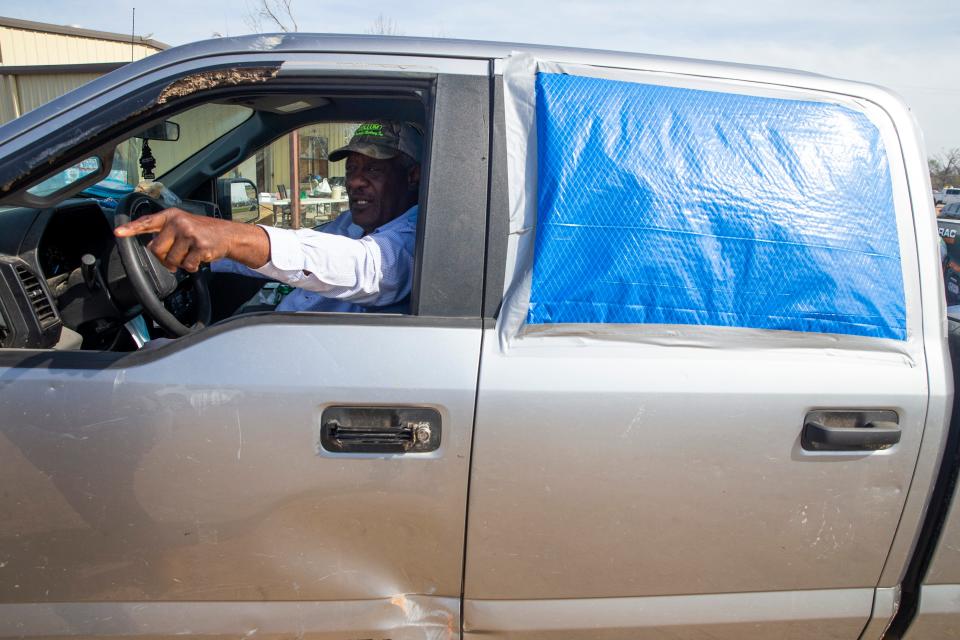 Humphreys County District Three Supervisor Woodrow Johnson points to a home impacted by the tornado as he sits in his damaged truck in Silver City on Tuesday. An EF-4 tornado damaged parts of Silver City and killed at least three residents on Friday night.