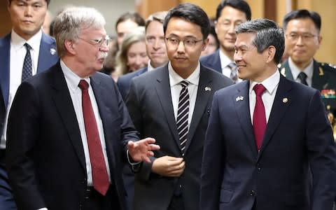 John Bolton speaks with South Korean Defence Minister Jeong Kyeong-doo in Seoul on Wednesday - Credit: Handout via Reuters