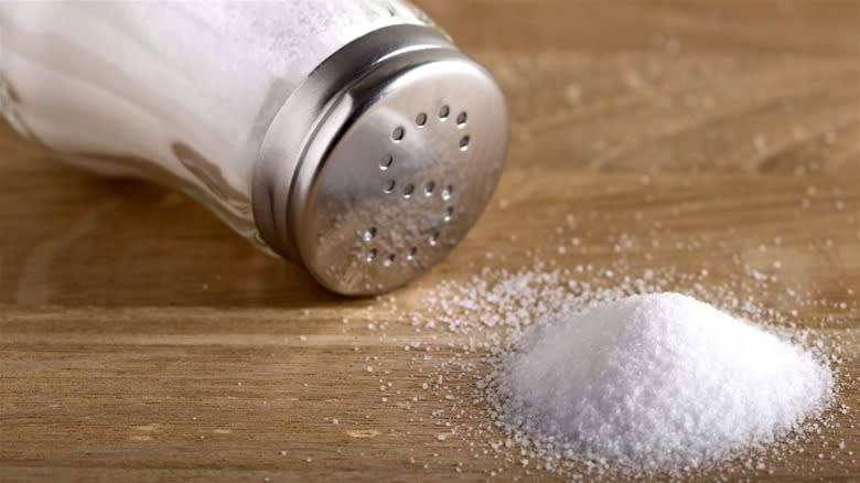 Table salt shaker spilling salt