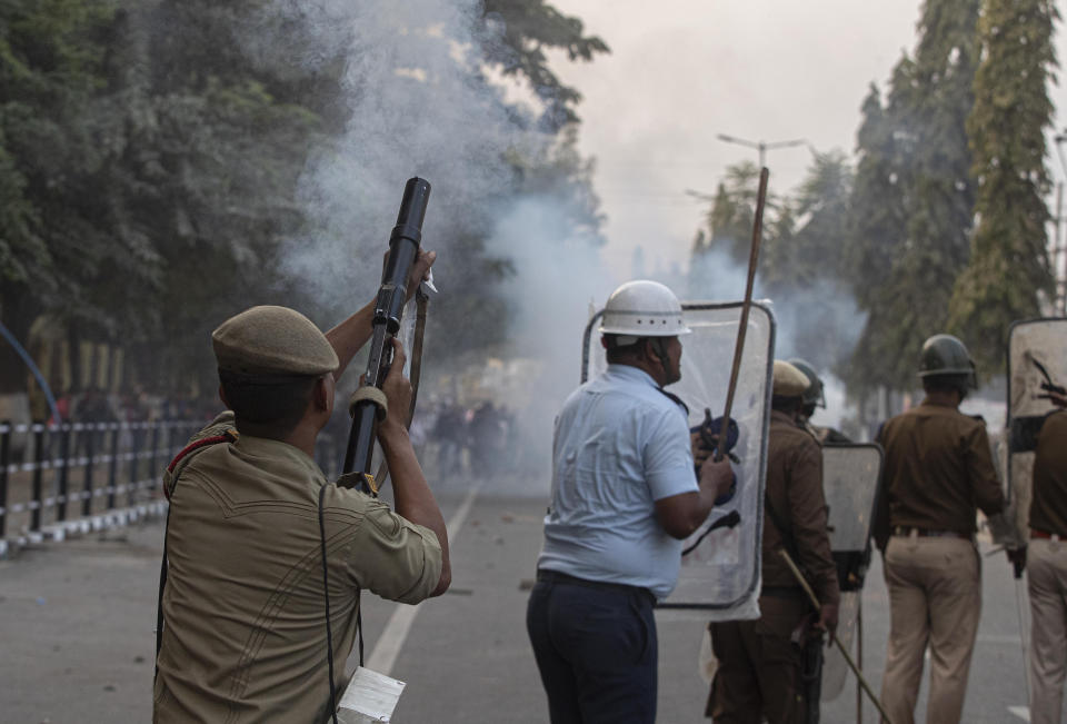 Police use tear gas shells to disperse protestors demonstrating against the Citizenship Amendment Bill (CAB) in Gauhati, India, Wednesday, Dec. 11, 2019. Protesters burned tires and blocked highways and rail tracks in India's remote northeast for a second day Wednesday as the upper house of Parliament began debating legislation that would grant citizenship to persecuted Hindus and other religious minorities from Pakistan, Bangladesh and Afghanistan. (AP Photo/Anupam Nath)