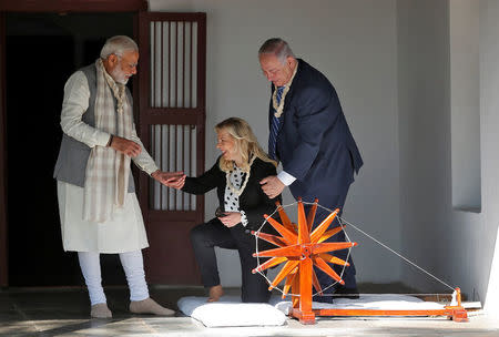 Indian Prime Minister Narendra Modi assists Israeli Prime Minister Benjamin Netanyahu's wife Sara as Netanyahu looks on during their visit to Gandhi Ashram in Ahmedabad, India, January 17, 2018. REUTERS/Amit Dave