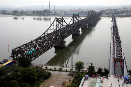 Trucks cross Friendship Bridge (L) from China's Dandong, Liaoning province (foreground), to North Korea's Sinuiju September 12, 2016. REUTERS/Thomas Peter