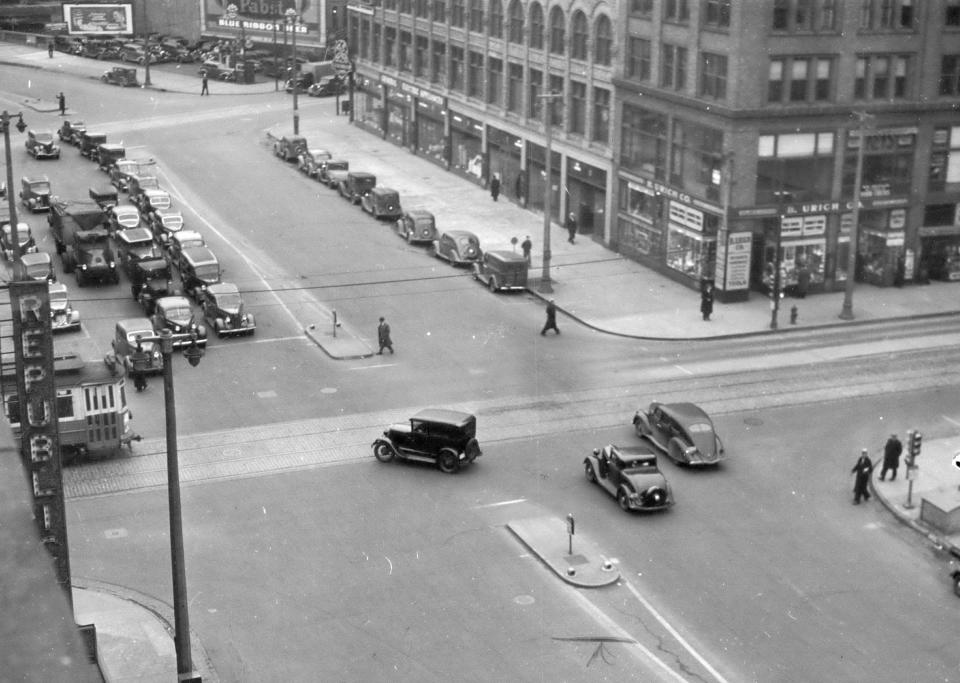 1937: Traffic lights along W. Kilbourn Ave. are being tested with westbound traffic set slower than eastbound traffic.  This picture was made from the roof of the Republican Hotel and shows cars traveling east past N. 3rd St. and W. Kilbourn Ave. Today the intersection is home to the Milwaukee Journal Sentinel, the Hyatt Regency Hotel and the Milwaukee Historical Society.