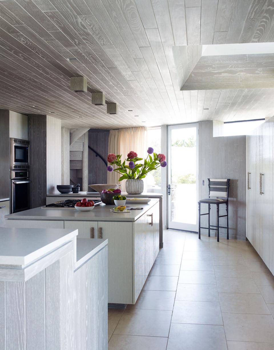 The fully renovated kitchen features custom cabinets covered in Kinon panels sanded to a matte finish. The barstool is an Ingrid Donat design from Carpenters Workshop Gallery.