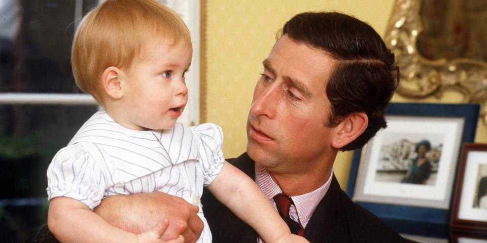 <p>Prince Charles holds a one-year-old Prince Harry in Kensington Palace. <br></p>