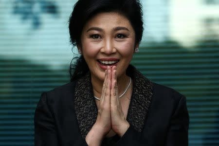 Ousted former Thai prime minister Yingluck Shinawatra greets supporters as she arrives at the Supreme Court in Bangkok, Thailand, August 1, 2017. REUTERS/Athit Perawongmetha/Files