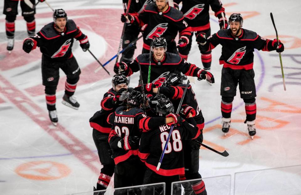 Carolina Hurricanesí Ian Cole (28) is surrounded by his teammates after scoring the game winning goal in overtime against the New York Rangers on Wednesday, May 18, 2022 during game one of the Stanley Cup second round at PNC Arena in Raleigh, N.C.