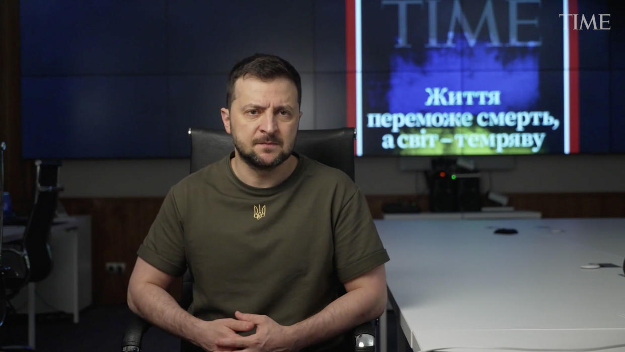 Screen shot of Volodymyr Zelensky speaking with a TIME cover in the background