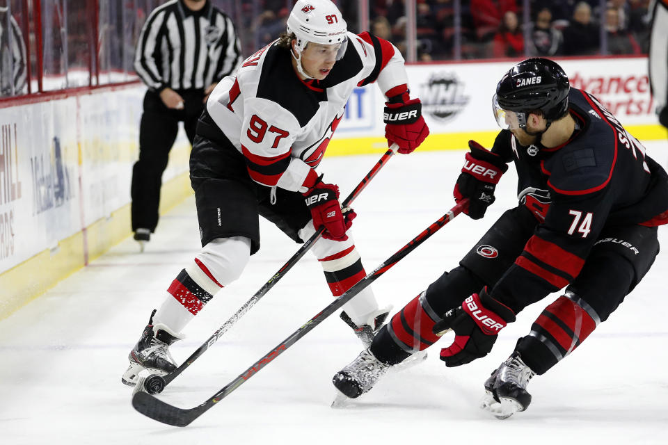 New Jersey Devils' Nikita Gusev (97), of Russia, works against Carolina Hurricanes' Jaccob Slavin (74) during the first period of an NHL hockey game in Raleigh, N.C., Friday, Feb. 14, 2020. (AP Photo/Karl B DeBlaker)