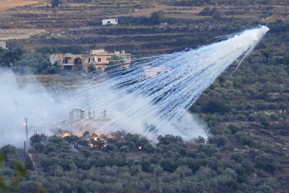 A shell from Israeli artillery explodes over a house in al-Bustan, a Lebanese border village with Israel, south Lebanon, Sunday, Oct. 15, 2023. (AP Photo/Hussein Malla)