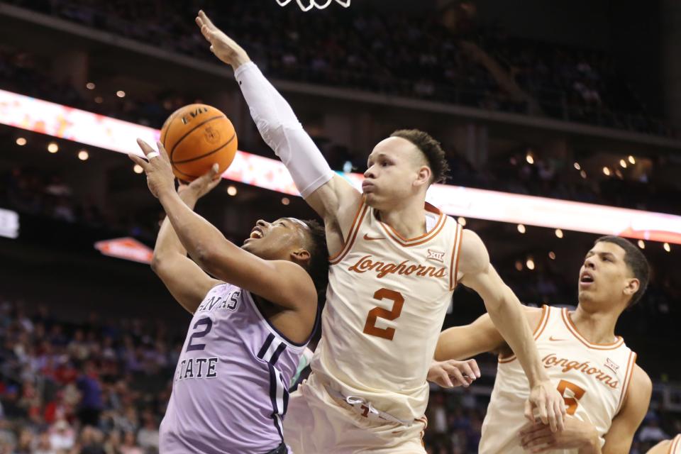 Kansas State guard Tylor Perry (2) looks for an opening under the basket against Texas' Chendall Weaver (2) on Wednesday night during their second-round Big 12 Tournament game at T-Mobile Center.