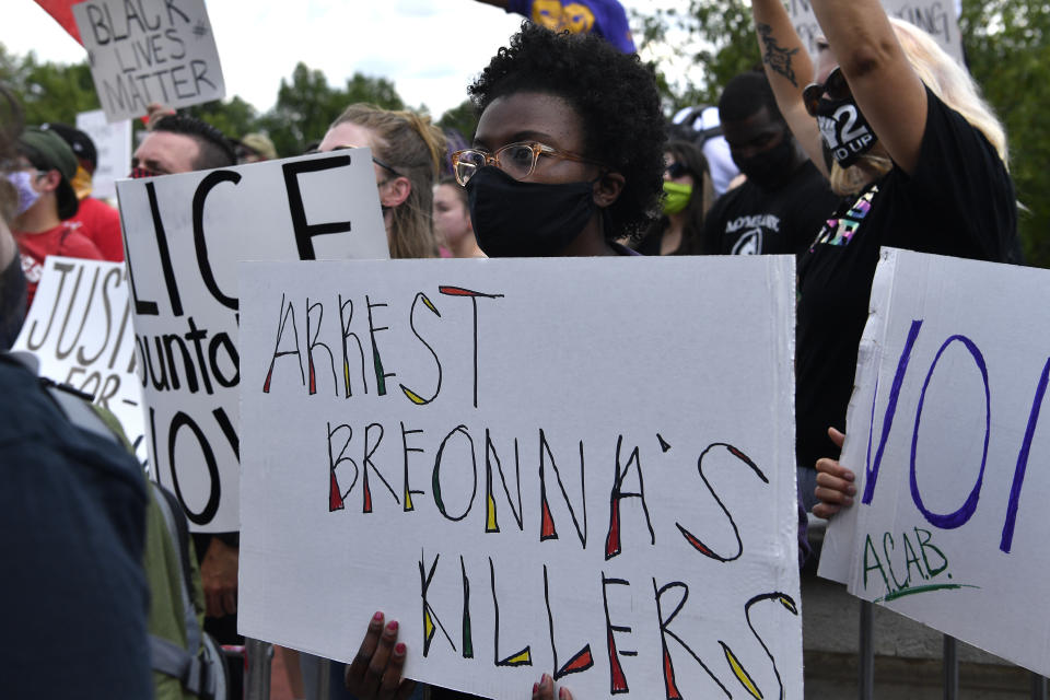 A woman holds up a sign during a rally in memory of Breonna Taylor on the steps of the Kentucky State Capitol in Frankfort, Ky., Thursday, June 25, 2020. The rally was held to demand justice in the death of Taylor who was killed in her apartment by members of the Louisville Metro Police Department on March 13, 2020. (AP Photo/Timothy D. Easley)