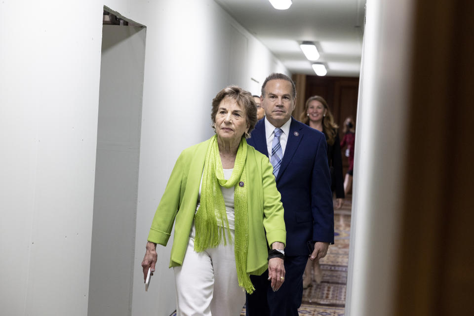 Rep. Jan Schakowsky, in lime-green top and scarf, and Rep. David Cicilline leave the Senate side of the U.S. Capitol Building.