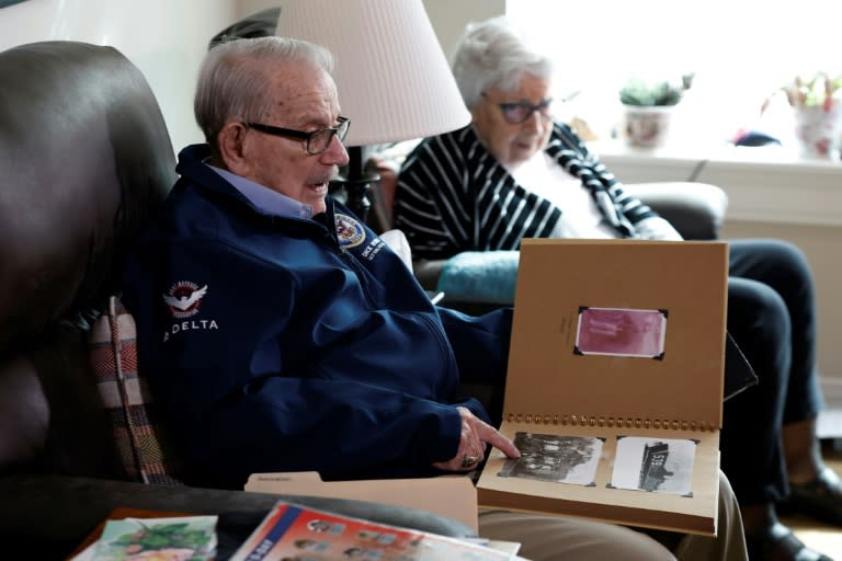 World War II veteran Richard Rung, pictured with his wife of 75 years Dorothy Rung, points to a photo in an album as he recalls his experiences on D-Day (KAMIL KRZACZYNSKI)