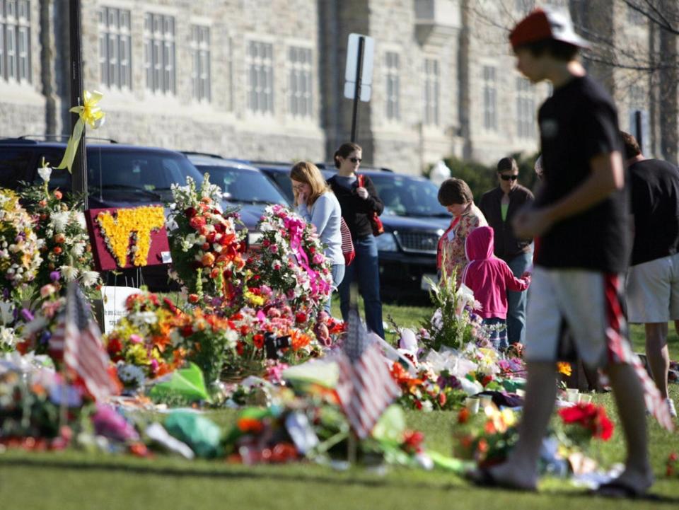 Mourners visit the “Hokie” stone memorial in honor of the 32 shooting victims at Virginia Tech in 2007 (AFP via Getty Images)