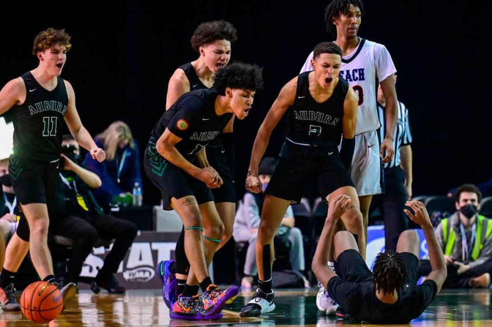 Auburn players run over to pick up guard Dae’Kwon Watson (24) after he fouled by Rainier Beach forward Jaelin Green (20) on an illegal screen in the final minutes of the fourth quarter of the Class 3A championship game on Saturday, March 5, 2022, at the Tacoma Dome, in Tacoma, Wash.