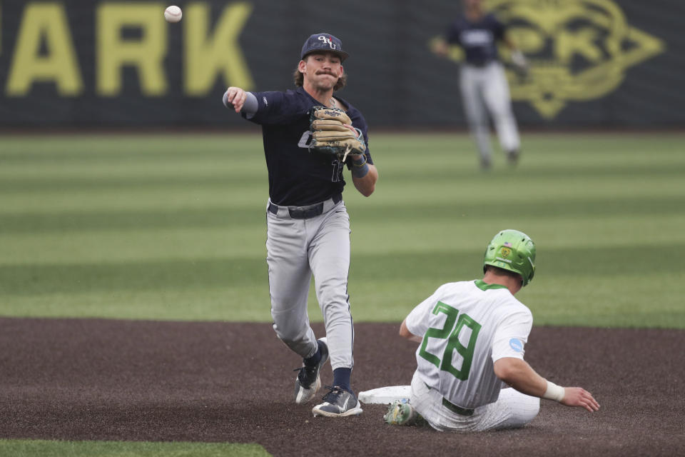 Oral Roberts' Mac McCroskey (12) throws to first base after forcing out Oregon's Bryce Boettcher (28) at second base during the third inning of an NCAA college baseball tournament super regional game Friday, June 9, 2023, in Eugene, Ore. (AP Photo/Amanda Loman)