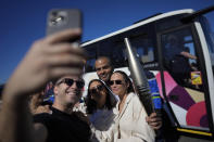 French torchbearer Tony Parker, rear center, poses for a selfie as he participates in the first stage of the Olympic torch relay in Marseille, southern France, Thursday, May 9, 2024. Torchbearers are to carry the Olympic flame through the streets of France' s southern port city of Marseille, one day after it arrived on a majestic three-mast ship for the welcoming ceremony. (AP Photo/Thibault Camus)