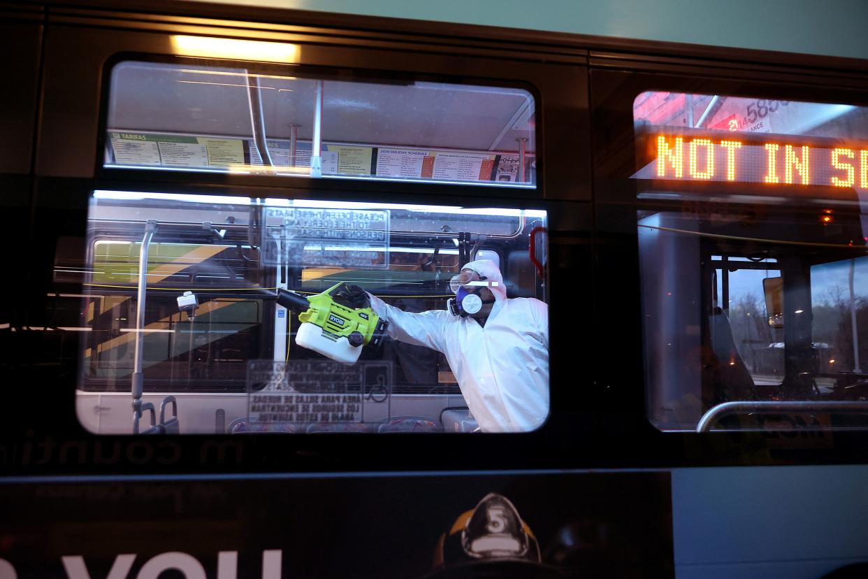 Wilfredo Quispe works through the night to disinfect public buses at the Montgomery County Division of Fleet Management Equipment Maintenance and Transit Operation Center March 20, 2020 in Rockville, Marylan