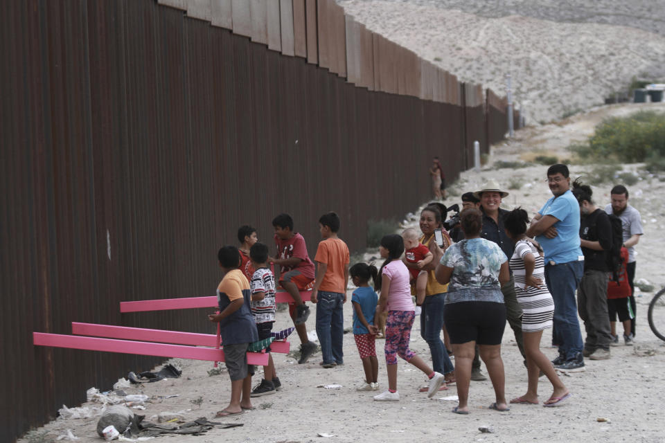 CORRECTS THE FIRST NAME OF THE PROFESSOR TO RONALD, NOT RONALDO AND THE LAST NAME OF THE PHOTOGRAPHER TO CHAVEZ, NOT TORRES - Children play seesaw installed between the border fence that divides Mexico from the United States in Ciudad de Juarez, Mexico, Sunday, July 28, 2019. The seesaw was designed by Ronald Rael, a professor of architecture in California. (AP Photo/Christian Chavez)