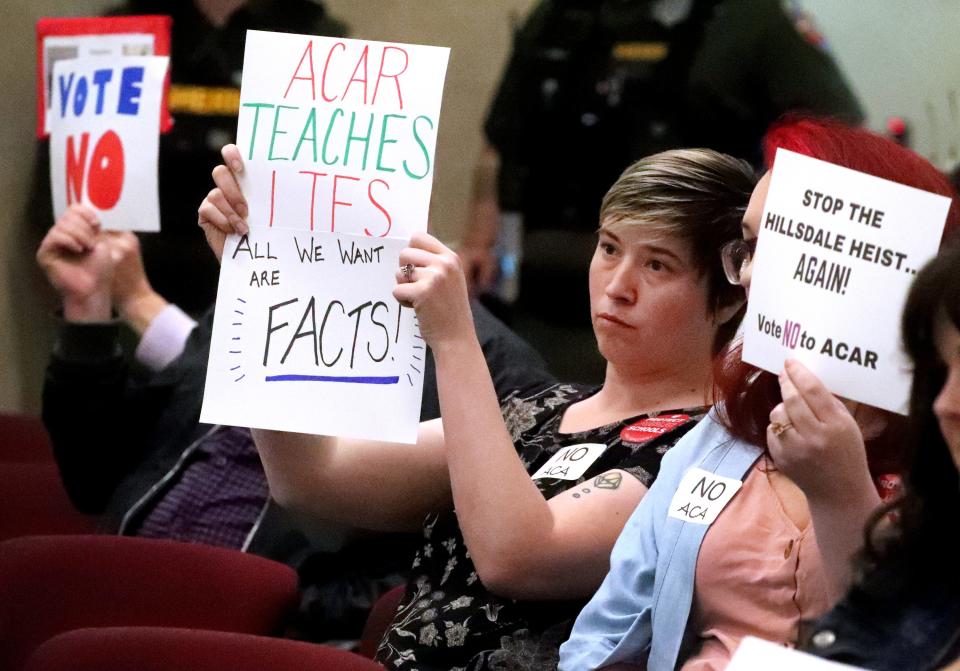 Leann Lewis holds up signs against the American Classical Academy Charter School, being added to the Rutherford County School System during a special called Rutherford County School Board meeting on Tuesday, April 25, 2023. The school board voted to accept the charter school, a Hillsdale College affiliate, to the Rutherford County Schools system during the meeting.