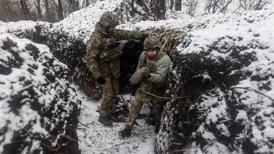 A Ukrainian soldier of the "Tsunami" regiment carries an artillery shell in the direction of Bakhmut as the war between Russia and Ukraine continues in Donetsk Oblast, Ukraine, on February 19, 2024. - Diego Herrera Carcedo/Anadolu/Getty Images