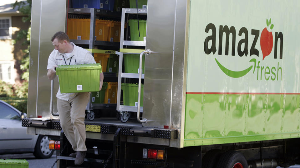 Amazon Fresh delivery man Tim Wilkie prepares a grocery order for delivery to a residence on Mercer Island, Wash., Thursday, Aug. 23, 2007. Amazon Fresh is a new grocery delivery service being tested by Amazon.com in a handful of Seattle neighborhoods including Mercer Island. Amazon.com has deployed a fleet of 12 grocery delivery trucks. Customers can also pick up fresh grocery orders at a small number of locations in the area. (AP Photo/Joe Nicholson)