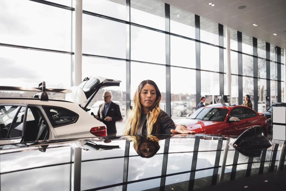 A woman shopping for a car at a dealership.