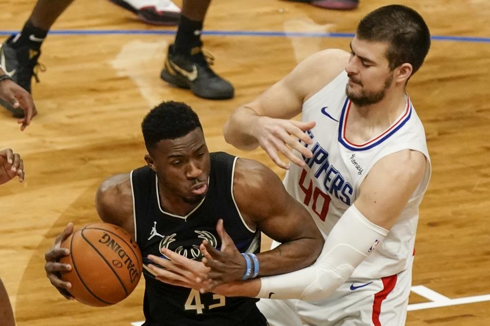 LA Clippers' Ivica Zubac tries to stop Milwaukee Bucks' Thanasis Antetokounmpo during the second half of an NBA basketball game Sunday, Feb. 28, 2021, in Milwaukee. (AP Photo/Morry Gash)