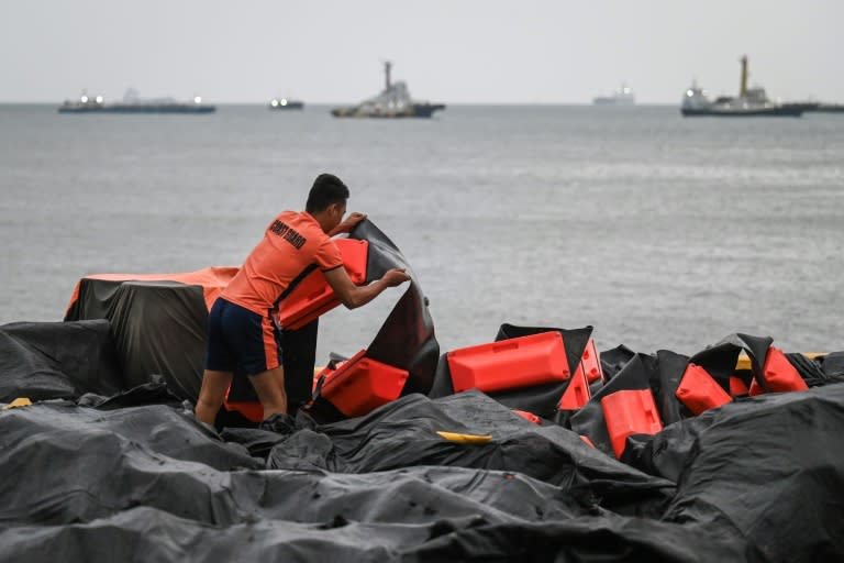 Un guardacostas prepara una barrera flotante para contener manchas de petróleo en el puerto de Limay, en Filipinas, el 25 de julio de 2024 (Jam Sta Rosa)