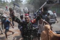 <p>A soldier calmed the panic residents during an powerful earthquake of 6.2 scala righter in Lombok, Indonesia, on Aug. 09, 2018. (Photo: Agoes Rudianto/Barcroft Media via Getty Images) </p>