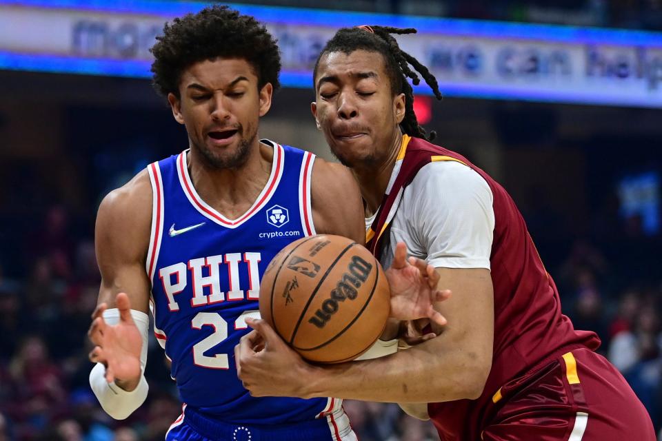 Cleveland Cavaliers center Moses Brown, right, rebounds against Philadelphia 76ers guard Matisse Thybulle (22) in the first half of an NBA basketball game, Sunday, April 3, 2022, in Cleveland. (AP Photo/David Dermer)