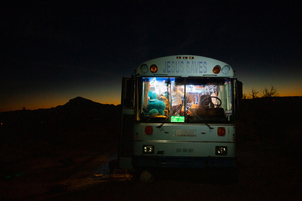 Paula and Max’s ‘Jesus Saves’ bus provides warmth on cold desert nights outside Lake Havasu City, Az., on Feb. 23. Paula was raised Jewish and does not identify as Christian; she found the retired Baptist school bus in San Diego last year and it fit within her budget.<span class="copyright">Nina Riggio for TIME</span>