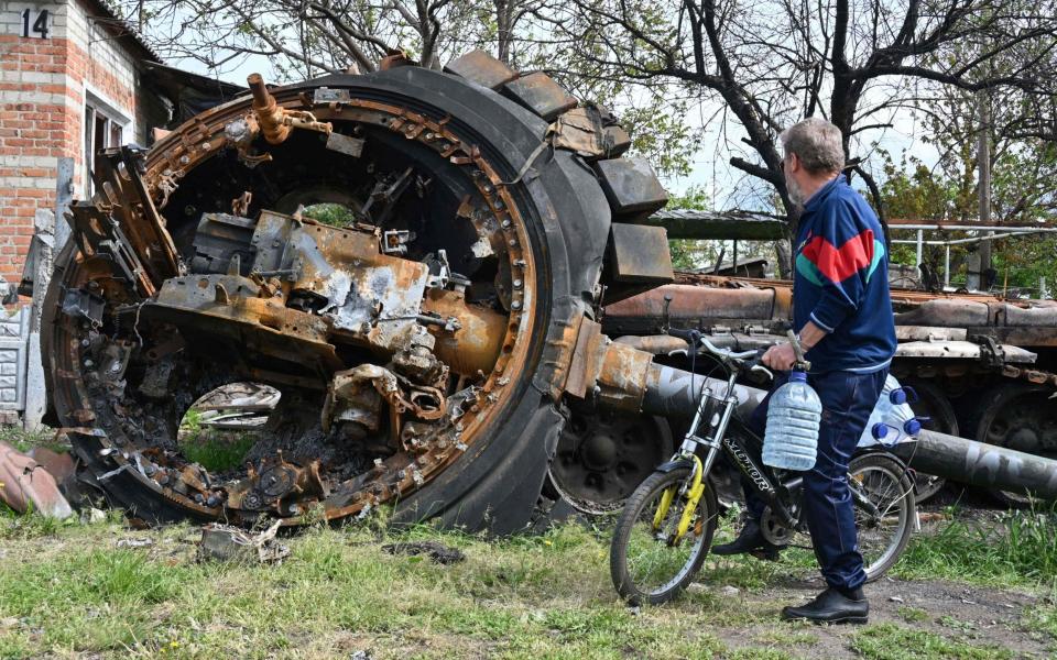 A Ukrainian civilian observes a destroyed Russian tank in Kharkiv, where the enemy has now suffered significant losses - Sergey Bobok/AFP via Getty Images 