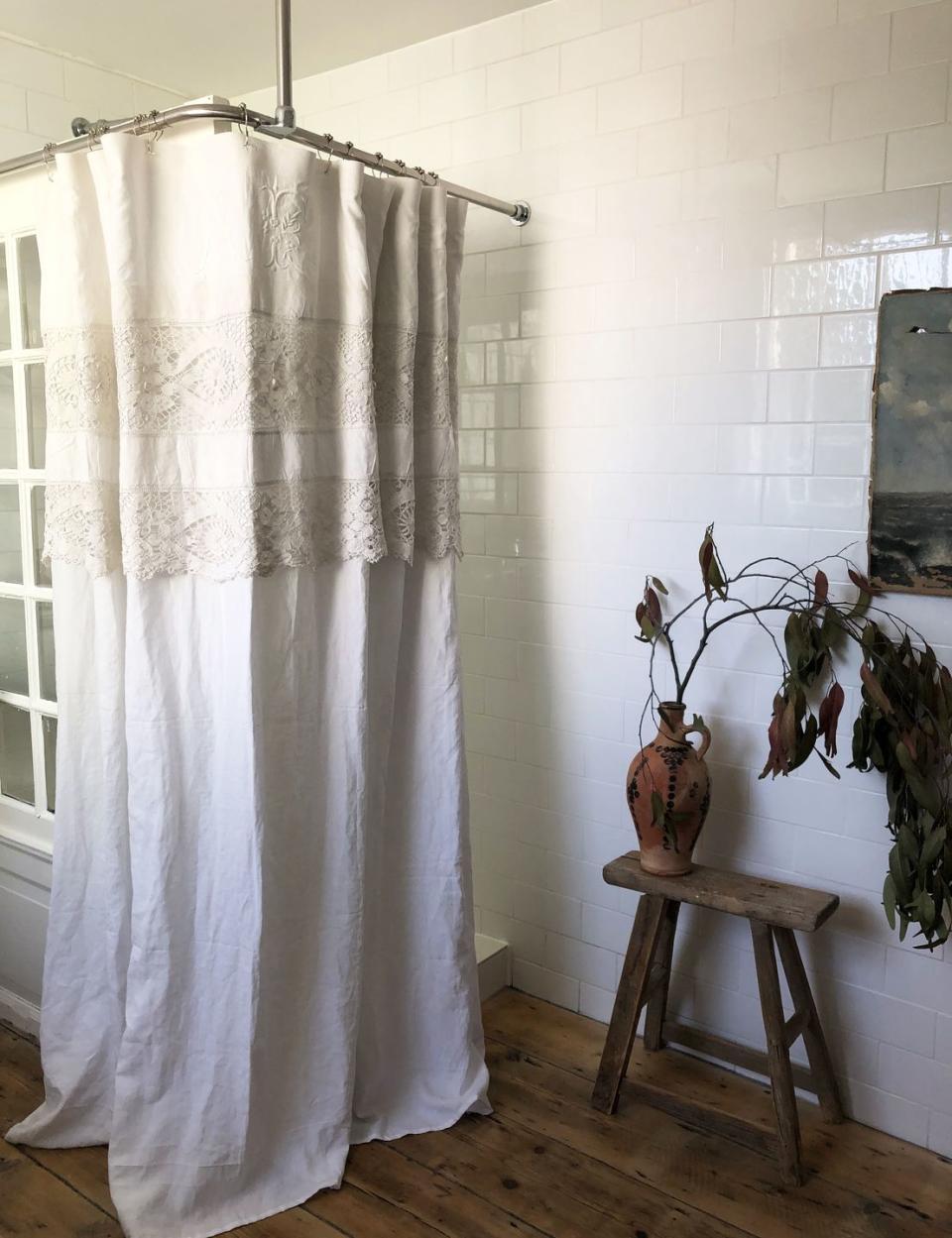 <p>"The shower screen is made from an old door that cost me £40 and I made the shower curtain from a beautiful linen and lace sheet. The floorboards were laid here as the original ones had perished and the painting was another antique find."</p>