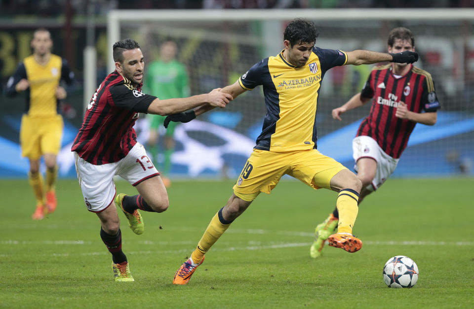 Atletico Madrid's Brazilian forward Diego Costa, right, challenges for the ball with AC Milan defender Adil Rami, of France, during a round of 16th Champions League soccer match between AC Milan and Atletico Madrid at the San Siro stadium in Milan, Italy, Wednesday, Feb. 19, 2014. (AP Photo/Emilio Andreoli)