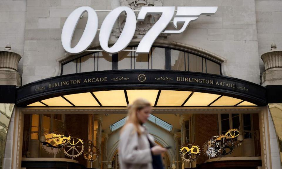 A pedestrian passes a James Bond 007 logo above the entrance to Burlington Arcade in London