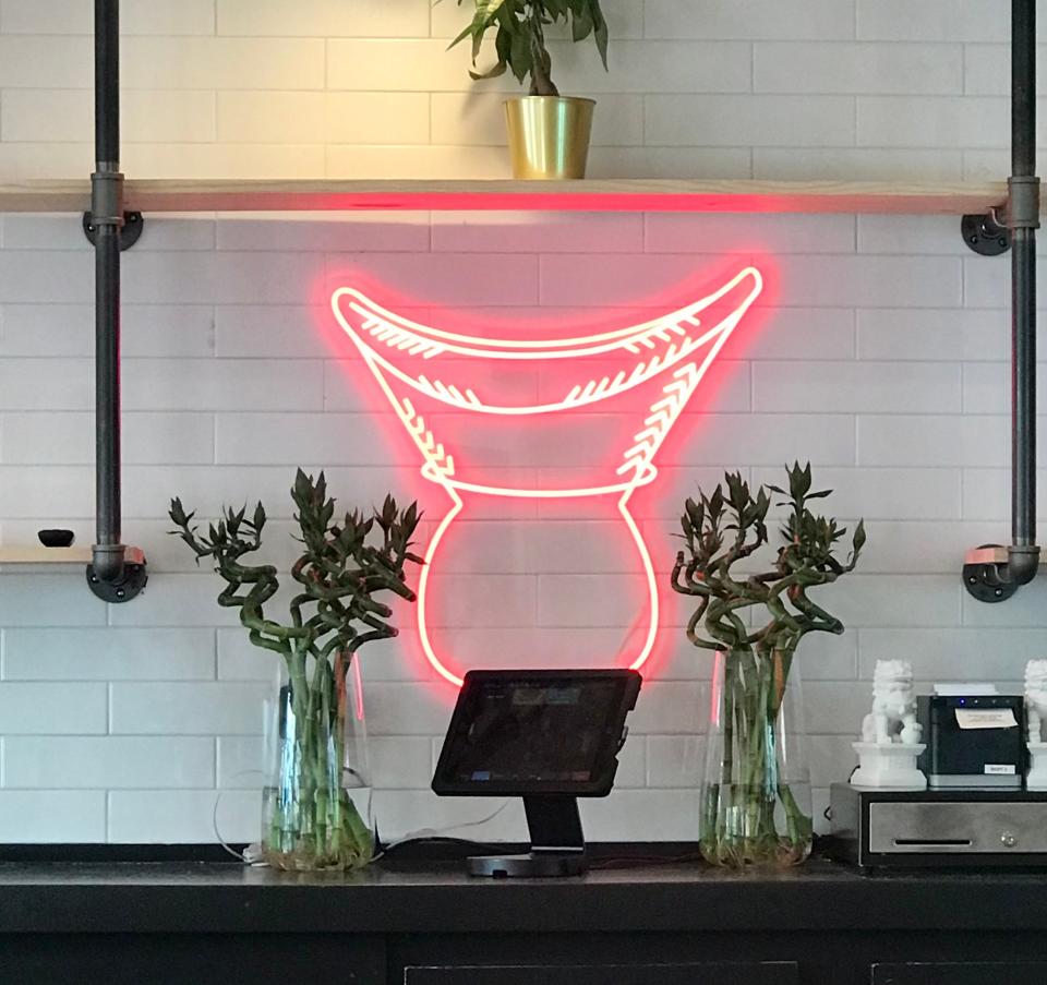 The basket that sticky rice traditionally is served in and the steamer it sits on are depicted in neon at the new Sticky Rice restaurant, 707 E. Brady St. It serves Lao and Thai dishes.