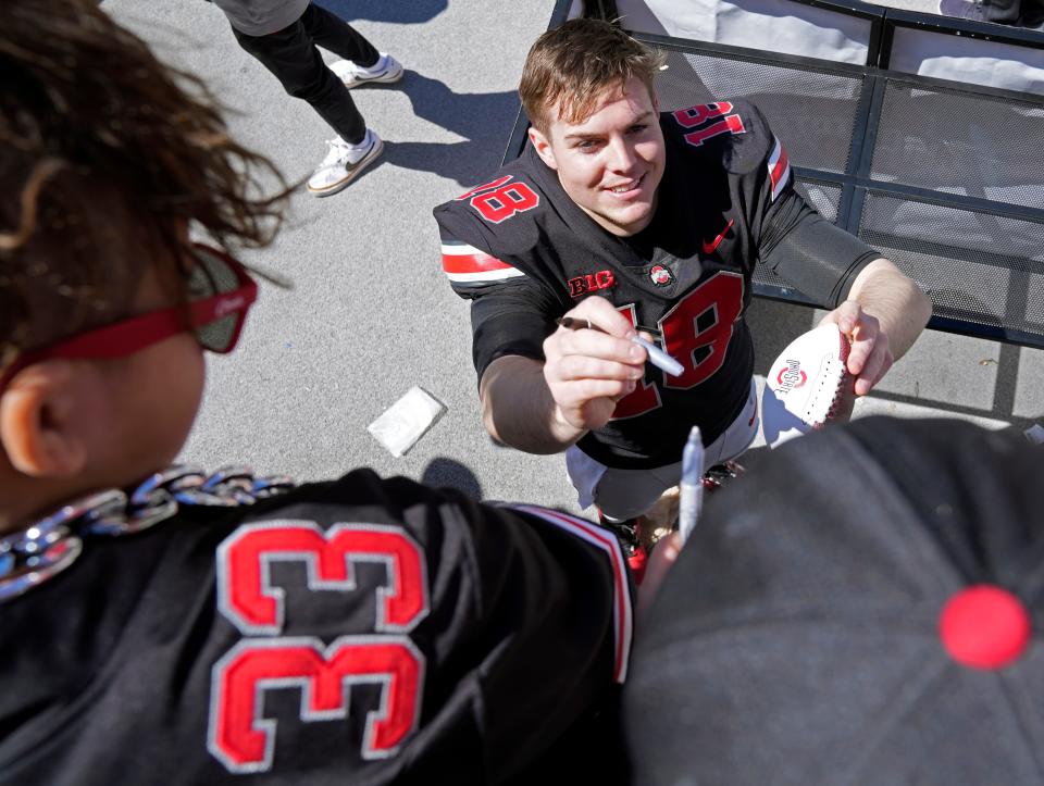 Ohio State quarterback Will Howard signs an autograph after Saturday's spring game.