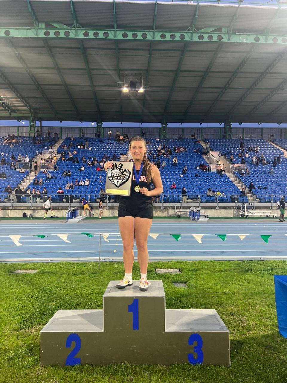 Marlboro's Juliana Juras poses with her first-place plaque at Icahn Stadium after setting a program record in the girls discus at the New York Relays on April 21, 2023.