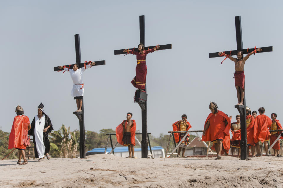 Three Filipino devotees are seen nailed on the cross as part of Good Friday rituals in the village of San Pedro Cutud, Pampanga province, northern Philippines, Friday, April 19, 2019. Over a thousand Filipino Roman Catholic devotees and tourists flocked to a farming village north of Manila on Friday to witness the crucifixion of several devotees in a costumed reenactment of Jesus Christ's sufferings, a gory annual tradition church leaders frown upon. (AP Photo/Iya Forbes)