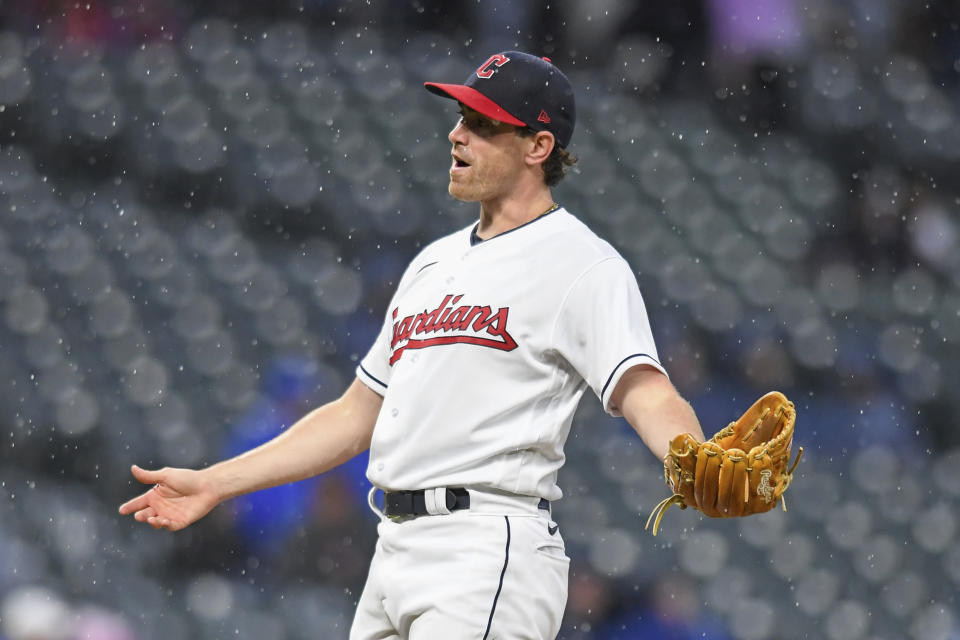 Cleveland Guardians starting pitcher Shane Bieber reacts as rainfall increases during the fifth inning of the team's baseball game against the Texas Rangers, Wednesday, June 8, 2022, in Cleveland. (AP Photo/Nick Cammett)