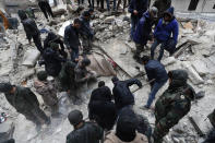 Syrian Civil Defense workers and security forces search through the wreckage of collapsed buildings, in Aleppo, Syria, Monday, Feb. 6, 2023. A powerful earthquake rocked wide swaths of Turkey and neighboring Syria on Monday, toppling hundreds of buildings and killing and injuring thousands of people. (AP Photo/Omar Sanadiki)