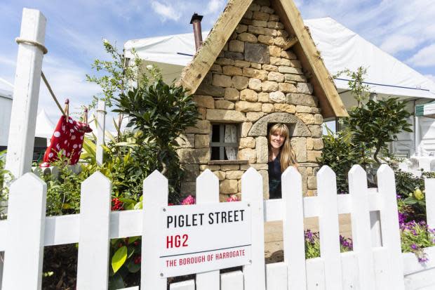 York Press: Faith Douglas peers out of Britains cheapest house. The house is part of a set design at Harrogate Flower show 2022 and will be on sale on Rightmove from tomorrow morning, pictured at Harrogate Flower Show, April 20 2022. See SWNS story SWLEhouse.