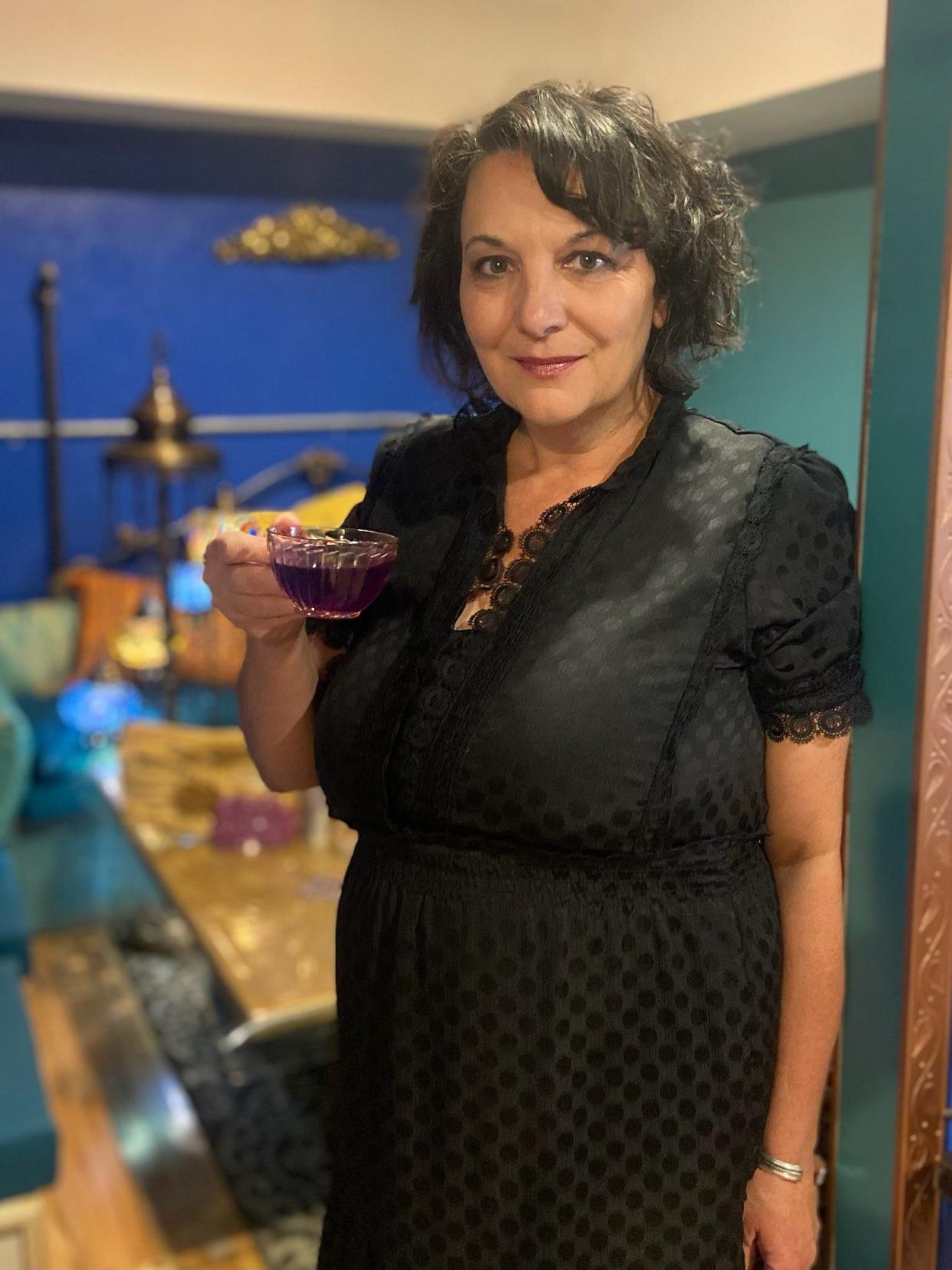 Pascha Haninah raises a glass of purple "magical butterfly" tea.