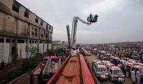 FILE PHOTO: Ambulances and fire brigade vehicles outside a building, after a fire at a garment factory in Karachi