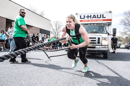 A participant in the May Queen Spring Strongwoman competition pulls a truck in Lancaster, Pennsylvania April 25, 2015. Courtesy of Amanda Kulik/Handout via REUTERS