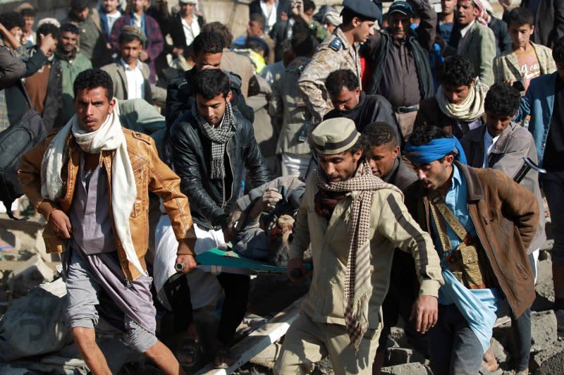 Yemeni men carry the body of a victim after pulling it from the rubble of a building destroyed by Saudi Arabian airstrikes against Houthi rebels near Sanaa Airport on March 26, 2015 in Sanaa, Yemen. File Photo by Mohammad Abdullah/UPI